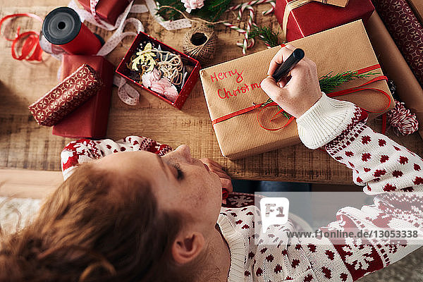Frau schreibt Grüsse auf Weihnachtsgeschenke