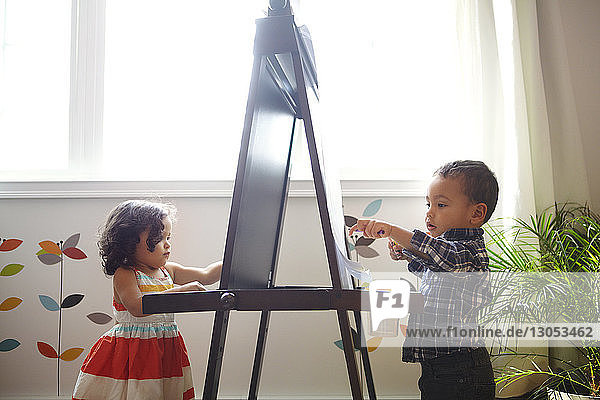 Kinder malen zu Hause an der Staffelei