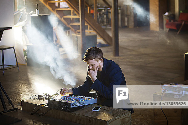 Man concentrating on audio equipment at home