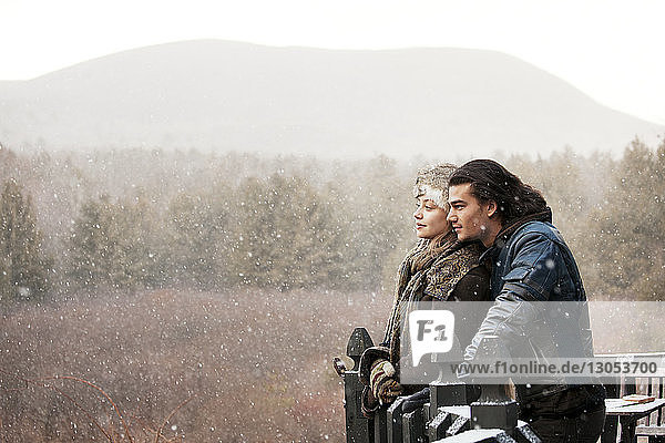 Glückliches Paar steht bei nebligem Wetter am Wald