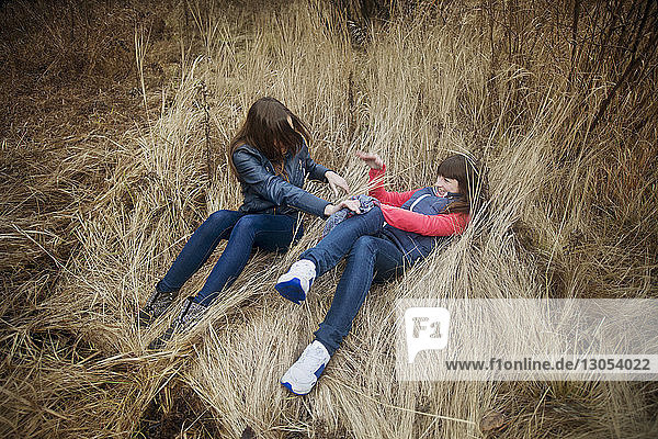 High angle view of female friends playing on grassy field