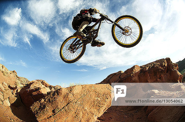 Mountainbiker beim Stunt in der Luft gegen den Himmel