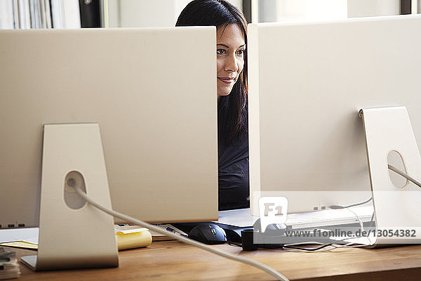 Businesswoman working on desktop computer at table in office