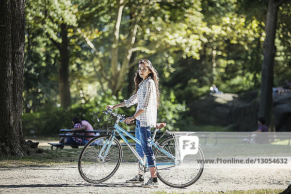 Porträt einer Frau mit Fahrrad auf einem Fussweg stehend