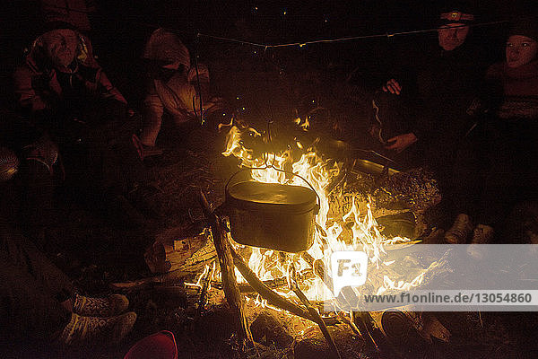 Freunde sitzen am Lagerfeuer auf dem Campingplatz