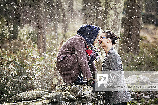 Side view of romantic couple in forest during winter