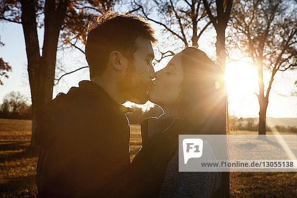 Seitenansicht eines zärtlichen Paares  das sich küsst  während es auf dem Spielfeld steht