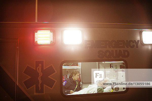 Sanitäter untersucht Mann nachts im Krankenwagen