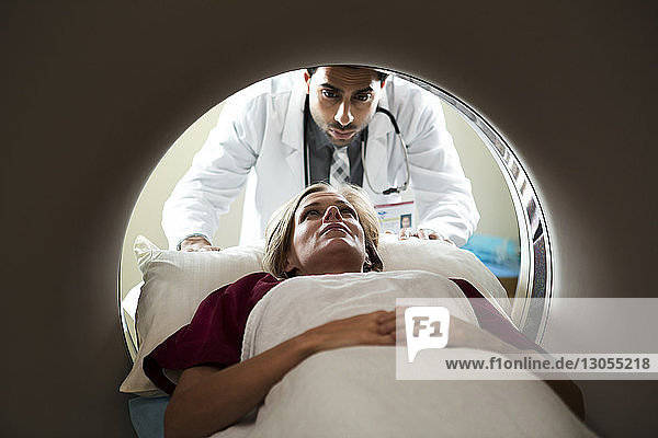 Frau unterzieht sich einem CAT-Scan durch einen im Krankenhaus stehenden Arzt