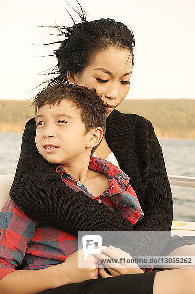 Mutter sitzt im Arm  Sohn im Boot