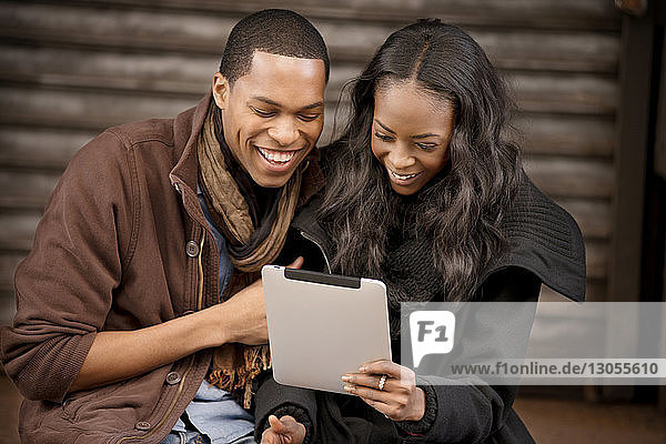 Glückliches Paar beim Blick auf das digitale Tablett