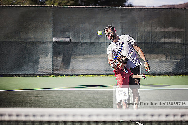 Vater und Sohn spielen Tennis auf dem Platz