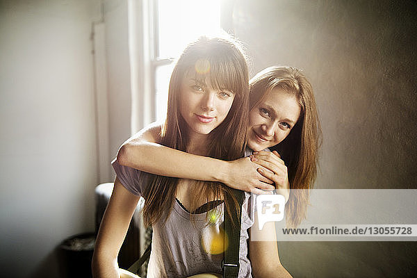 Portrait of smiling female friends at home