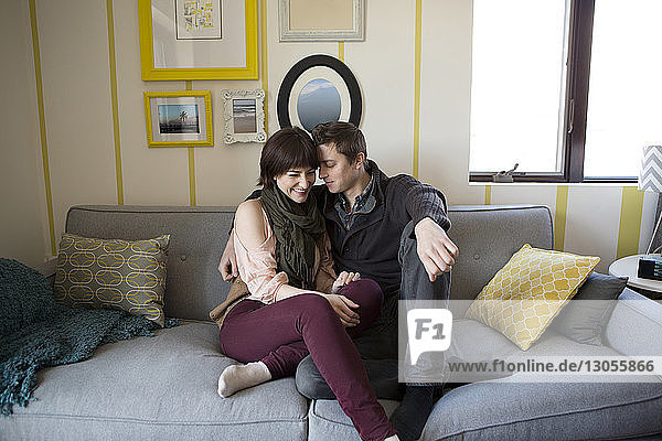 Romantic couple sitting on sofa at home