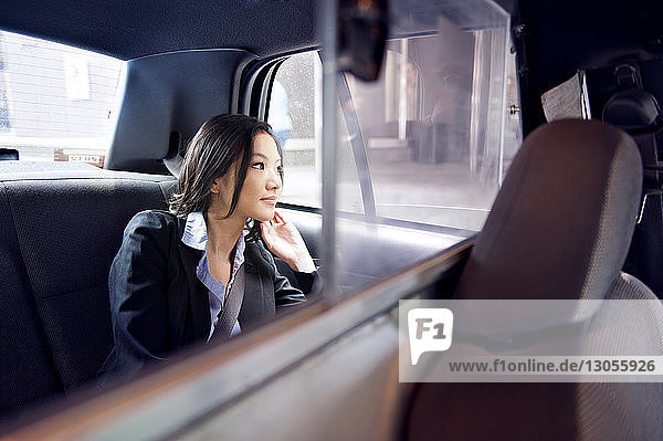 Nahaufnahme einer Geschäftsfrau  die durch ein Autofenster schaut