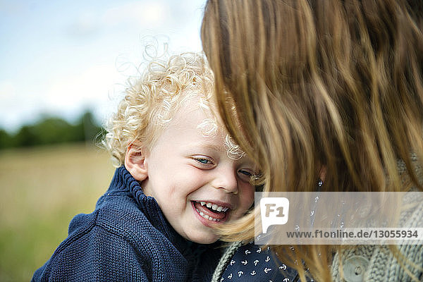 Close-up of mother carrying smiling son