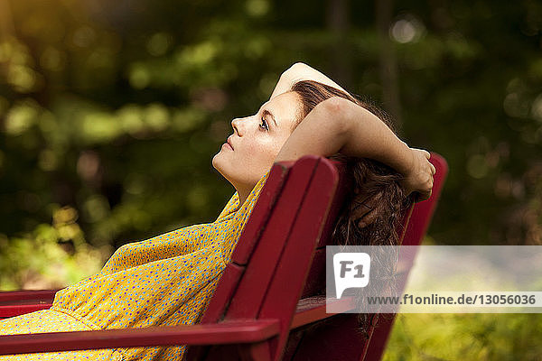 Seitenansicht einer Frau  die sich auf einem Liegestuhl entspannt