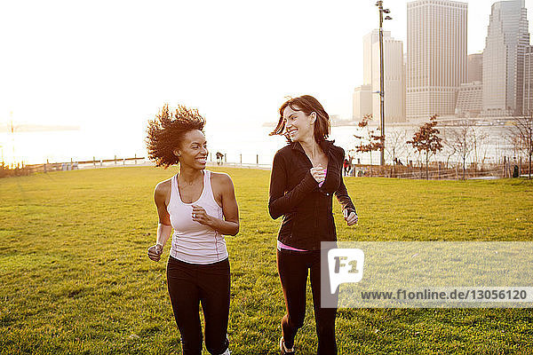 Glückliche Freundinnen joggen im Stadtpark