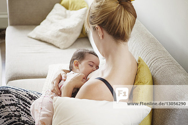 Hochwinkelansicht einer Mutter  die ihr Baby zu Hause stillt