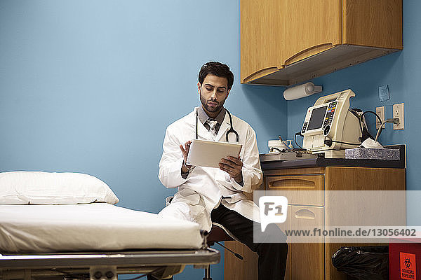 Arzt mit Laborkittel mit Tablet-Computer im Krankenhaus