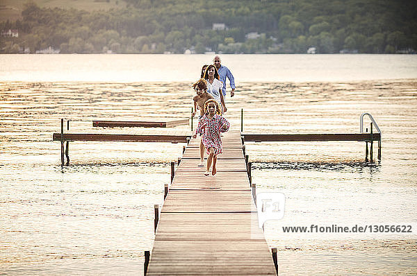 Familie geniesst auf dem Steg über dem See