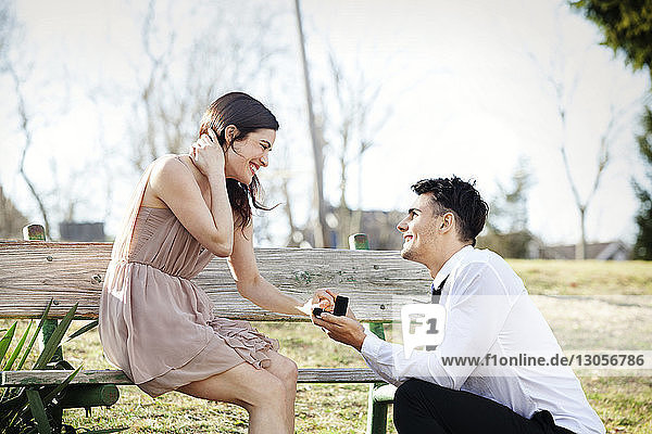 Mann macht seiner Freundin im Park einen Heiratsantrag