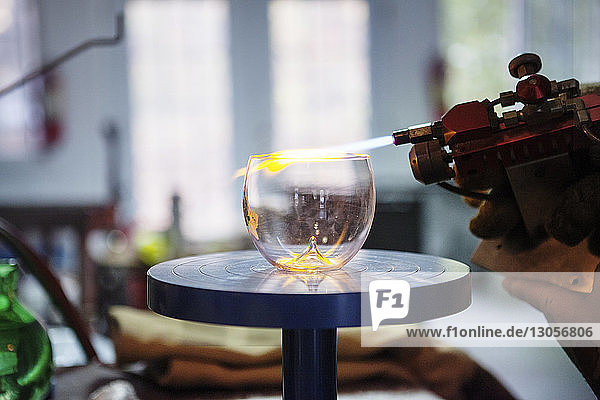 Beschnittenes Bild eines Glasbläsers  der Glas in der Werkstatt herstellt