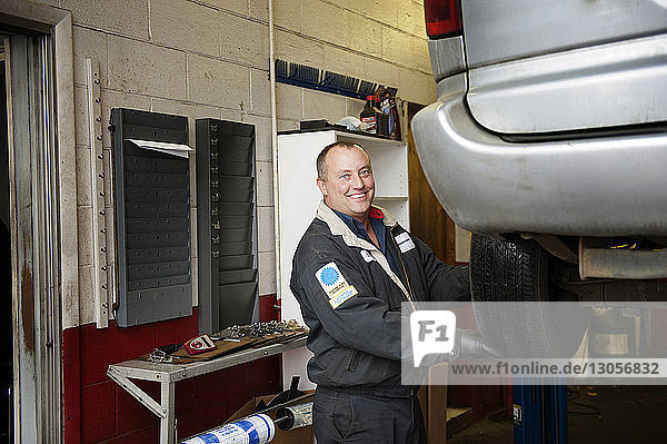 Portrait of happy mechanic working at auto repair shop