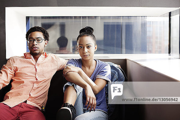 Portrait of couple sitting on sofa at home