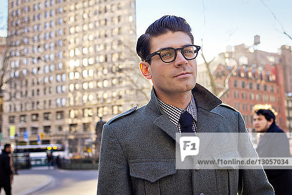 Portrait of businessman standing on street in city