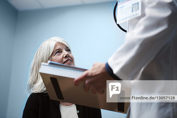 Ausgeschnittenes Bild eines Arztes im Gespräch mit einem Patienten im Krankenhaus