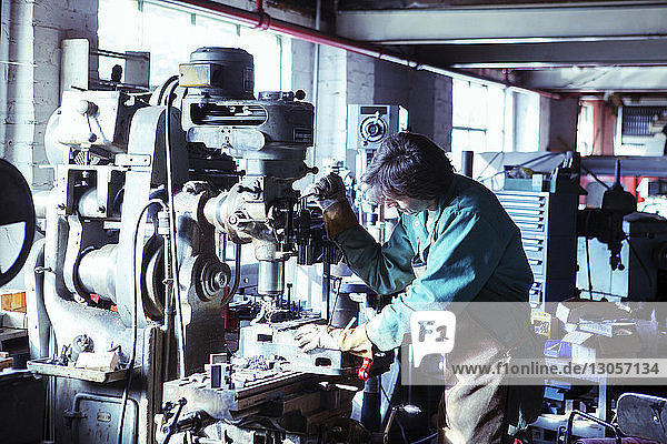 Arbeiter bedient Maschine in der Werkstatt