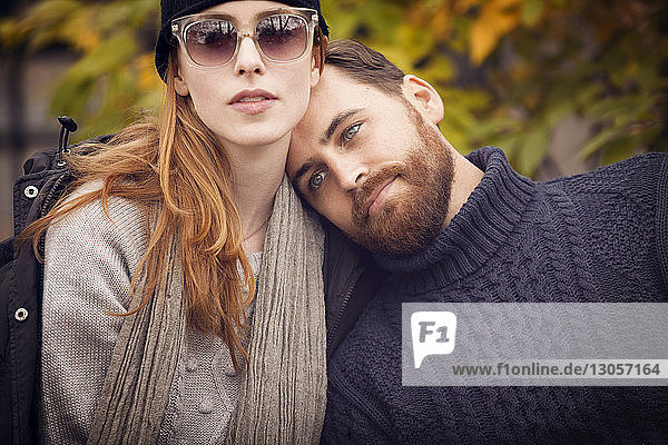 Man leaning head on woman's shoulder at park