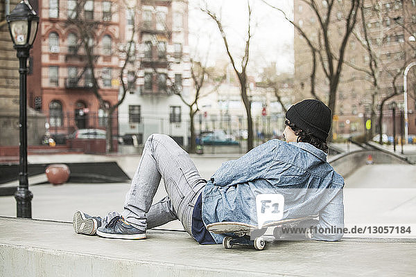 Rear view of man relaxing on seat at skateboard park