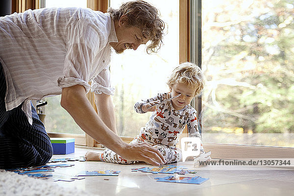 Father and son arranging jigsaw puzzle at home