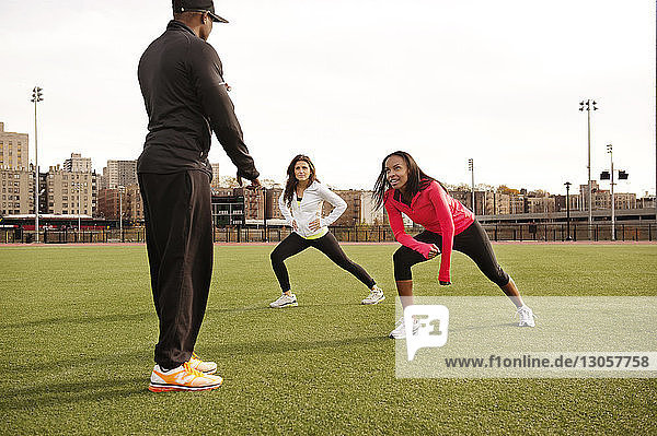 Trainerin trainiert Sportlerinnen auf dem Spielfeld in der Stadt