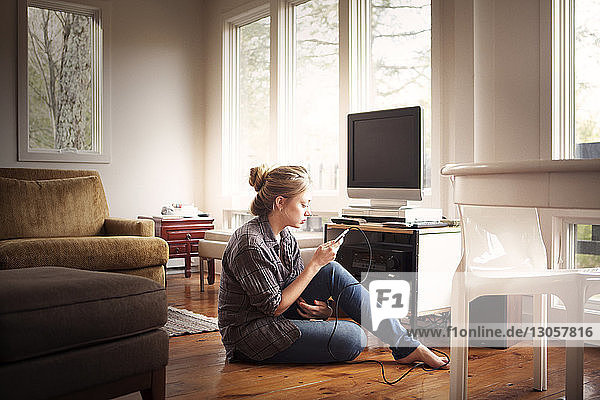 Woman using mobile phone while sitting at home