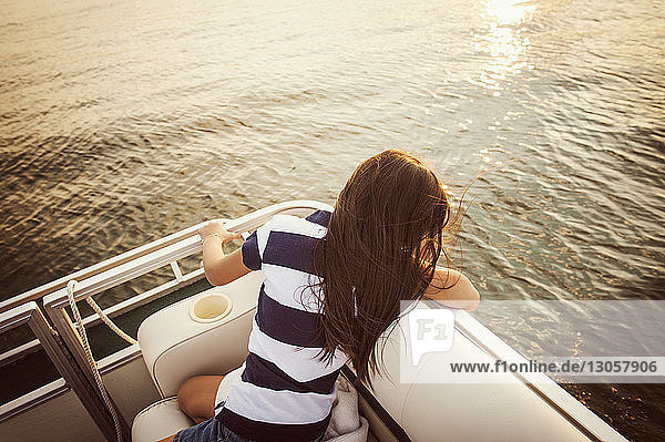 Hochwinkelaufnahme eines Mädchens  das in einem Boot auf dem See sitzt