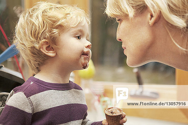 Nahaufnahme eines Jungen  der Eis isst  während er die Mutter ansieht