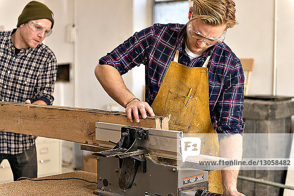 Männlicher Schreiner bei der Arbeit mit Holz in der Werkstatt