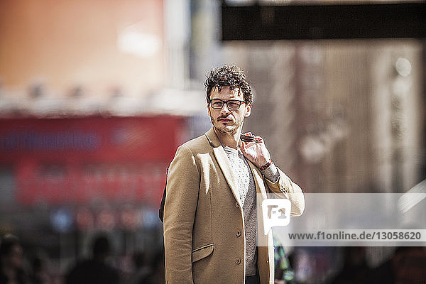 Businessman looking away while standing at city street