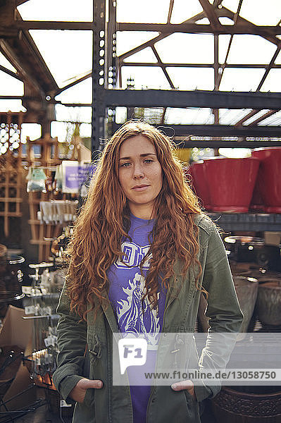 Portrait of confident woman standing in plant nursery