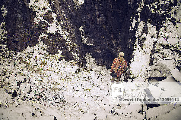Hochwinkelaufnahme eines Mannes  der auf einem schneebedeckten Berg wandert