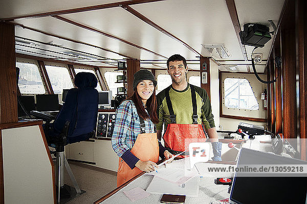Portrait of man and woman standing in fishing boat