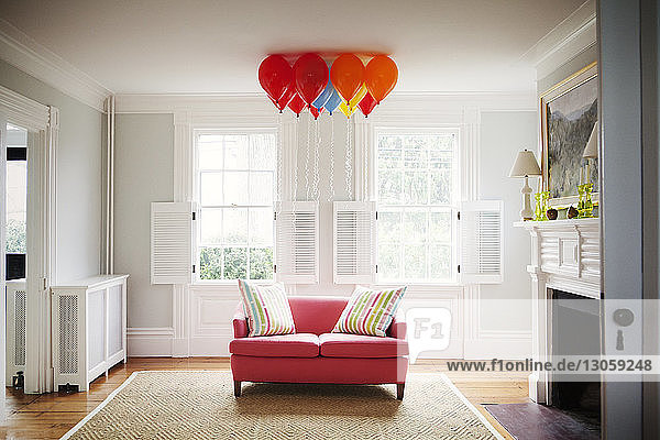 Heliumluftballons über dem Sofa im Wohnzimmer zu Hause