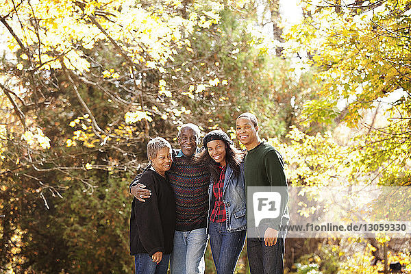 Portrait of family in forest on sunny day