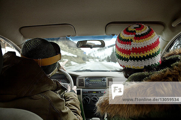 Rückansicht der im Auto sitzenden Freunde
