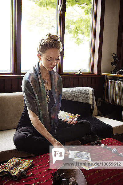 Tarot card reader placing cards while sitting at home