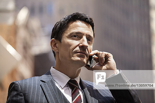 Close-up of confident businessman using mobile phone