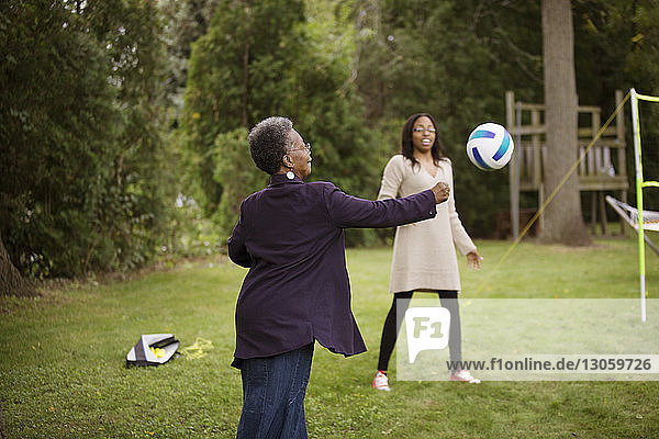 Ältere Frau und Enkelin spielen mit dem Ball im Hinterhof